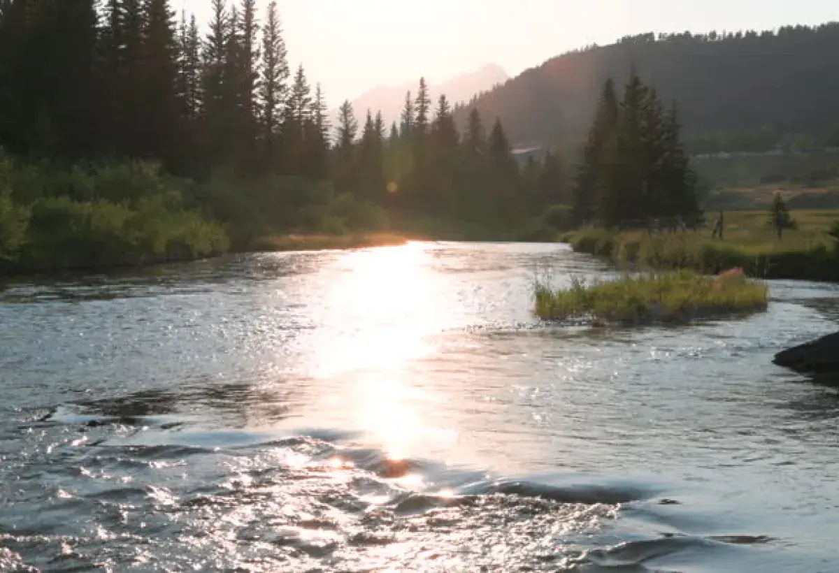 Sunlight over a flowing river representing God’s presence filling the soul