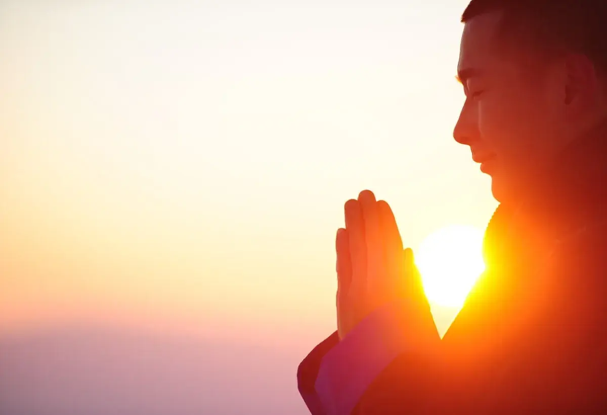man praying with sunrise background