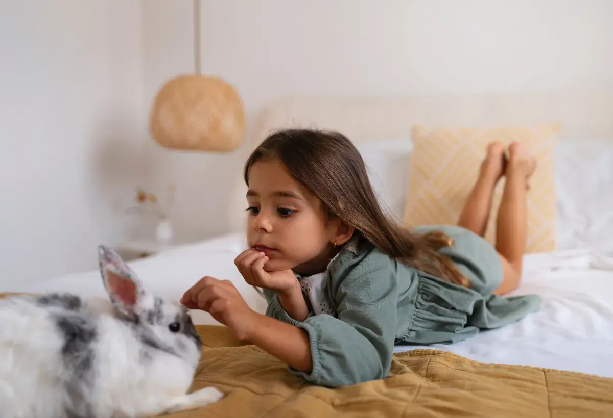 little girl on her bed with a rabbit