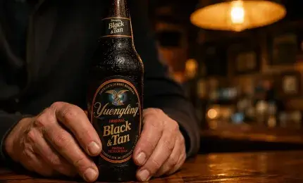 Hands holding a beer bottle in a warm quiet bar