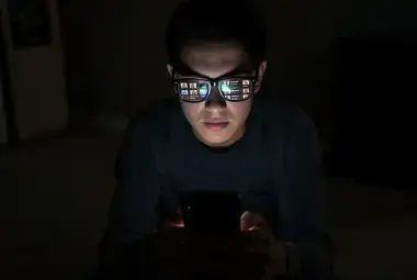 Smartphone glow reflecting in glasses during late night scrolling