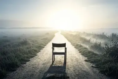 A powerful, symbolic, and thought-provoking image that visually represents the core theme: the consequences of inaction and the power of choosing change. Consider a striking, minimalist photograph or digital illustration. The central image is a simple, empty chair placed at a crossroads in a vast, open landscape. One path leading away from the chair is clear, well-lit, and stretches toward a bright, hopeful horizon—representing the unknown but purposeful journey of change. The other path is overgrown, shrou